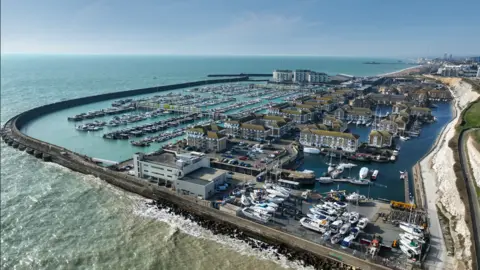 A marina is seen from above on a sunny day. 