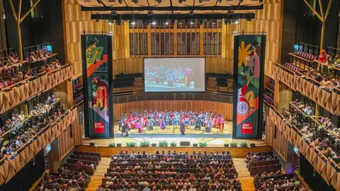 UWE Hundreds of students and their families sit in seats at the Bristol Beacon for a UWE graduation ceremony. The picture is taken from the upper tier of the music venue