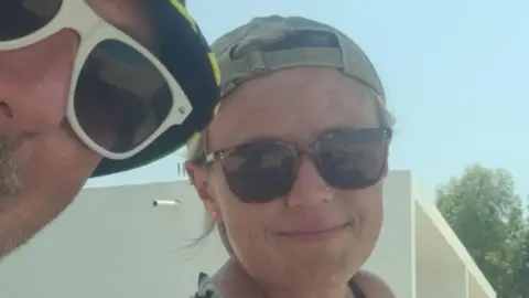 Alex Griffiths and his wife Danni both wear dark glasses and hats in a selfie