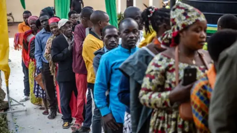 Rwandan voters stand in line as they prepare to vote in the 2024 elections