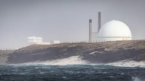 Dourneay nuclear power station's dome near a rocky coast and the sea