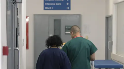Two doctors walking through a hospital corridor.
