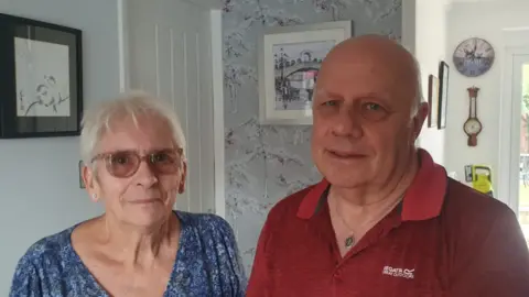 couple man on right in red polo shirt and woman with blue dress