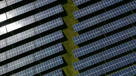 An aerial view shows the photovoltaic (PV) solar panels making up Manston Solar Farm, in south-east England on March 18, 2024. 