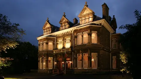 Mansion house a victorian mansion in the evening light lit up from inside 