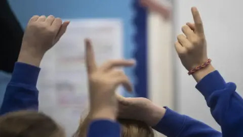 PA Children's hands in the air in a school setting