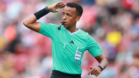 Omar Artan signalling for play to continue