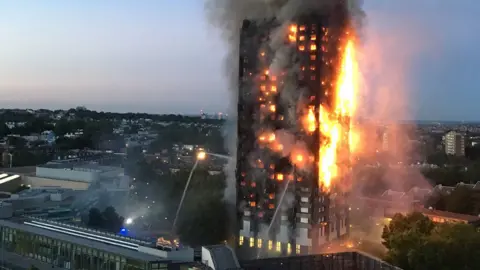 AFP/Natalie Oxford Grenfell Tower in the early hours of 14 June