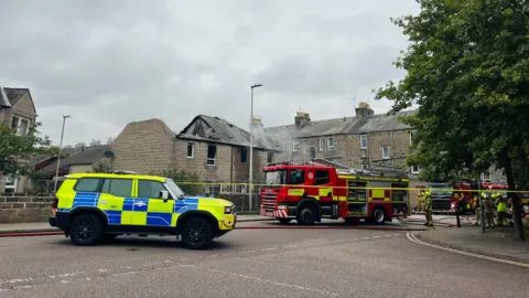 Police and fire crews at the scene of a house fire.