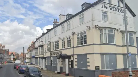 The Windsor pub in Bridlington. The building is painted cream, white and grey and bears the name of the pub on the side and front walls.
