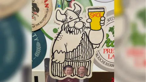 Rob Derry Beer mat depicting comic strip character Hagar the Horrible raising a glass of beer with the test skol typed on it, surrounded by other beer mats not fully visible