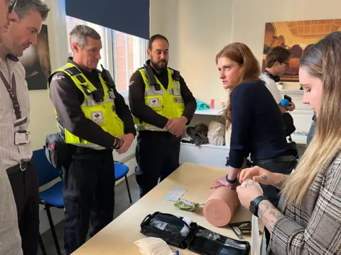 Olimpia Zagnat/BBC Elena demonstrating a life-saving method  to assistance   victims who person  been progressive   successful  a stabbing