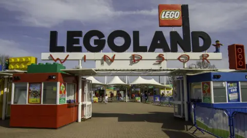 Getty Images/Wirestock A general view picture of the entrance to Legoland Windsor, with two entrance kiosk on the left and right below a sign that says Legoland Windsor.
