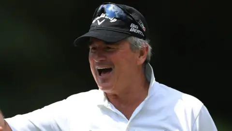 Getty Images Allan Lamb with dark hair and beard wearing cricket whites and a black cap