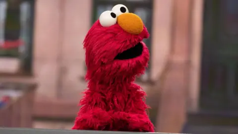 Elmo, a red fluffy puppet