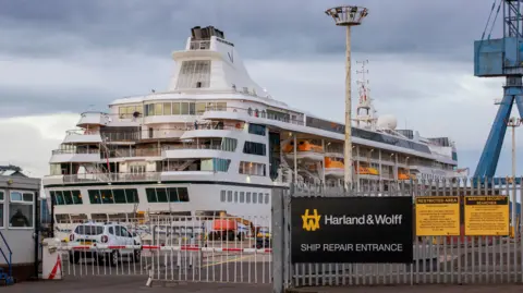 PA Media Villa Vie Odyssey cruise ship at Belfast Port behind a gate saying 'Harland & Wolff Ship Repair Entrance. 