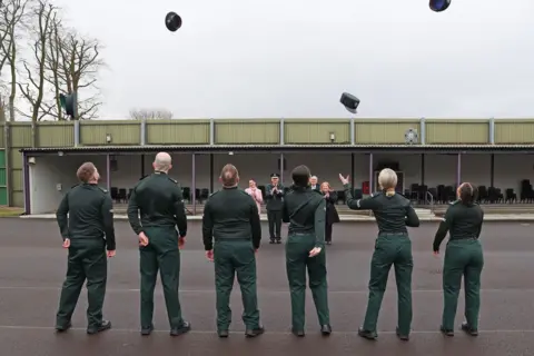 PA Media Police officers throwing hats in the air at passing out parade