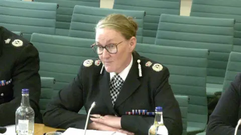 BBC Merseyside Chief Constable Serena Kennedy, who has glasses and blonde hair in tied a bun, speaks to MPs. She is wearing her black police uniform.