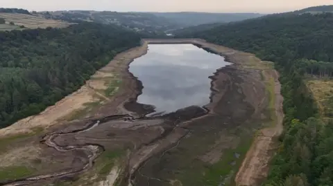 PA Media Drone image of a reservoir in England with depleted water. The dried out banks of the reservoir can be seen
