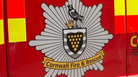 A red fire engine door with Cornwall Fire & Rescue written on a logo.