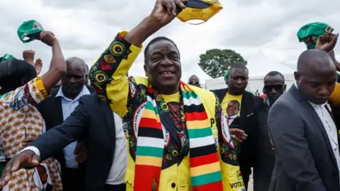 AFP Zimbabwe's President Emmerson Mnangagwa (C) gestures as he arrives for a "Thank You" rally on November 24, 2018, in Murombedzi, Zvimba, Mashonaland West, Zimbabwe