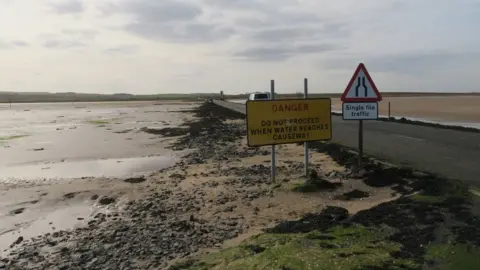 RNLI/Ian Clayton Warning sign about the tidal causeway, Holy Island