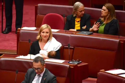 Reuters Senator Larissa Waters breastfeeds her daughter Alia Joy in Australian parliament.