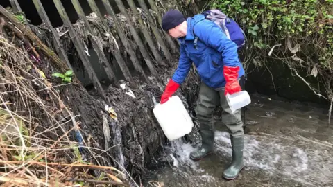 Jamie Woodward Scientist takes samples from a combined sewer overflow on the River Tame