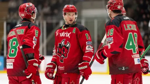 Three Cardiff Devils players in conversation.