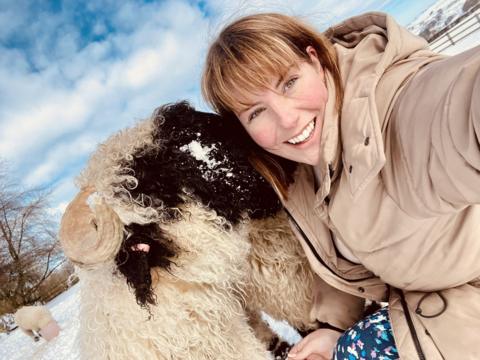 Kate Sturdy and her sheep posing for a photo in the snow