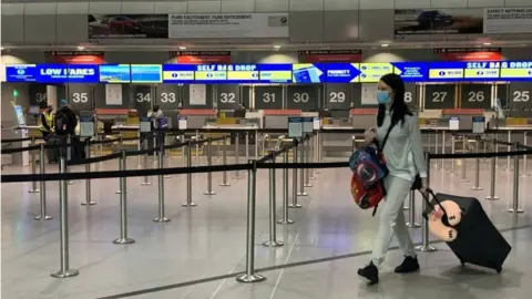 Reuters Passenger in mask at Manchester Airport