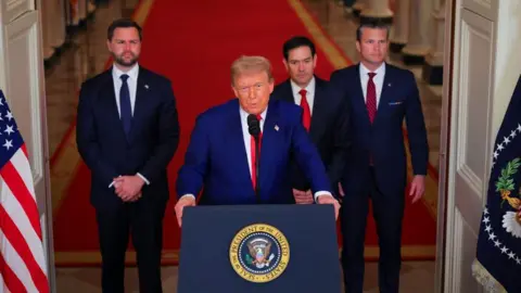 Four men stand in suits