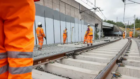 LDRS Workers stand by tracks that are being replaced on the Metrolink tram network in Greater Manchester.