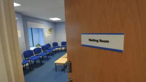 BBC An empty waiting room at a GP surgery