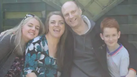 Family photo A family photo of Abbigail, her parents and her brother. They are all smiling at the camera