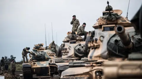 Getty Images Turkish tanks gather close to the Syrian border, 21 January 2018