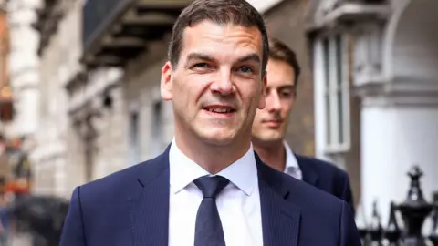 Olly Robbins pictured in a dark suit leaving the Cabinet Office on Whitehall 