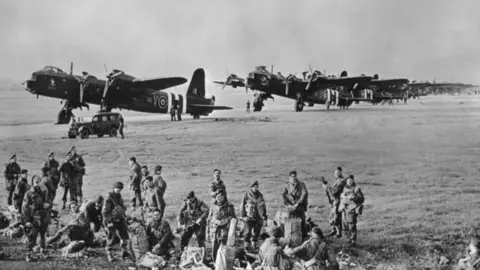 Getty Images Paratroops from 3rd Platoon, 21st Independent Parachute Company, British 1st Airborne Division prepare their parachutes and equipment before emplaning into Short Stirling Mark IV converted heavy bombers of No 620 Squadron RAF for the airborne drop to secure the landing zones at Arnhem during Operation Market Garden on 17th September 1944 at RAF Fairford, Gloucestershire, England. Black and white image showing soldiers packing kit bags with Stirlings behind them.