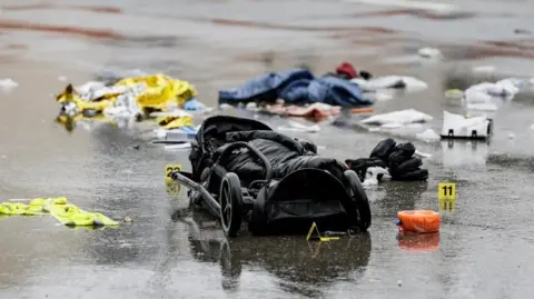 Image shows a black pushchair on the ground at the site where a vehicle was driven into a demonstration in Munich, Germany on 13 February 2025