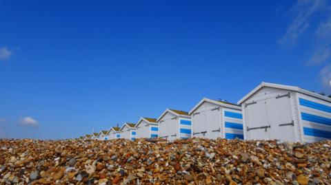 Blue skies over beach huts in Hastings