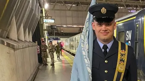 An RAF recruit carrying a flag