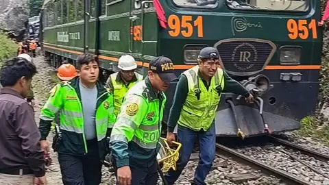 AFP Photo: Getty Images Rescuers transport an injured person along a railway line. 