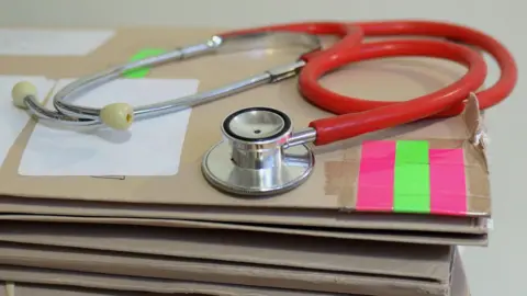 Stethoscope on top of a pile of folders.
