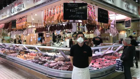 Loic Garcia stands in front of his family's food stall