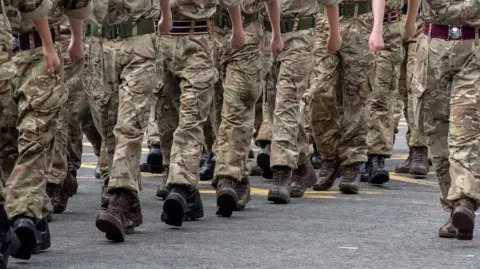 Getty Images Close up shot of the legs of British soldiers who are in uniform and marching through the street