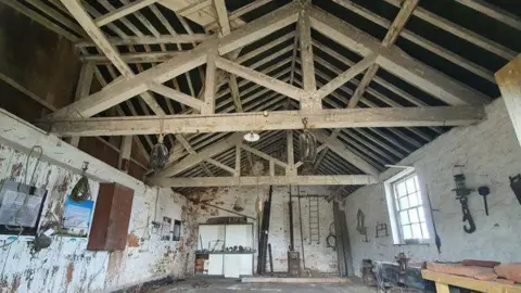 Laura Marie Brown Inside one of the building on the island, the ceiling beams are exposed and the paint is peeling off the walls