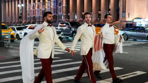 Workers believed to be a part of the reported wedding between singer Taylor Swift and National Football League (NFL) player Travis Kelce, crosses a road outside Madison Square Garden, in New York City, U.S., July 3, 2026.