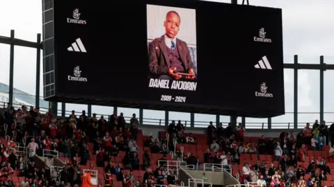 TOLGA AKMEN/EPA-EFE/REX/Shutterstock  Screens show a picture in memory of schoolboy Daniel Anjorin, who was fatally stabbed in a sword attack on his way to school