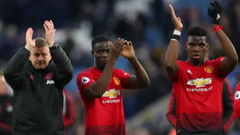 Manchester United interim boss Ole Gunnar Solskjaer (left), defender Eric Bailly (centre) and Paul Pogba (right) applaud fans after victory over Leicester