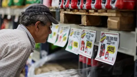 Reuters A man checks prices at a supermarket in Buenos Aires